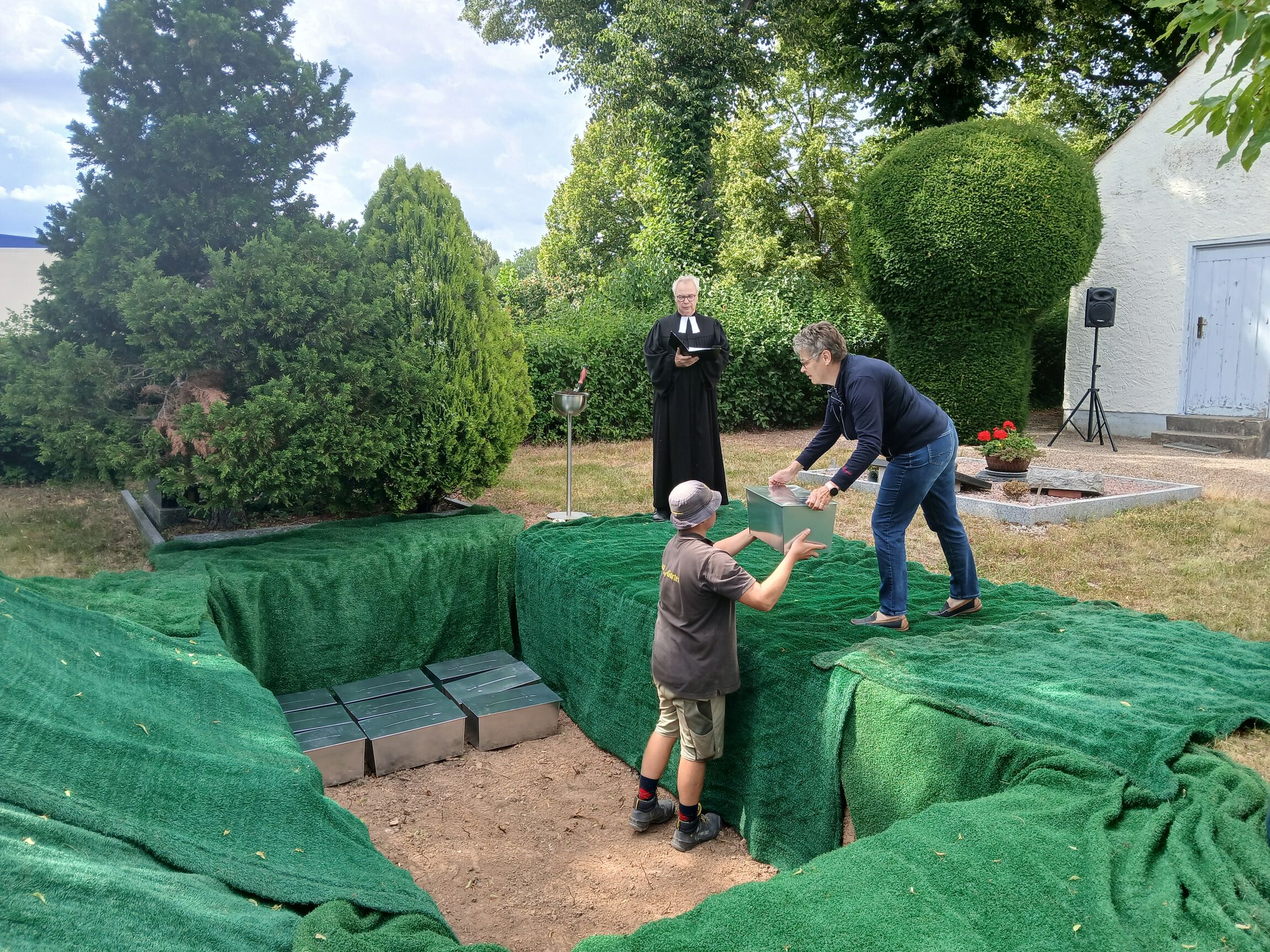 Ein Mitarbeiter der Firma Neddermeyer nimmt die Särge mit den vor 200 Jahren verstorbenen Elzern von der städtischen Mitarbeiterin Beate Freimann entgegen. Im Hintergrund steht Pastor Dr. Jens-Arne Edelmann.