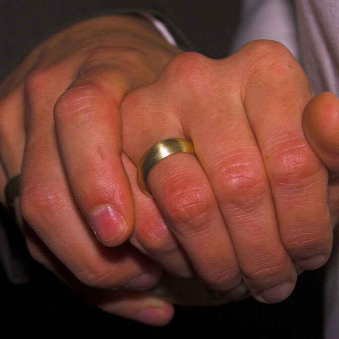 Bild: Hände eines Brautpaares ineinander, mit Ringen.